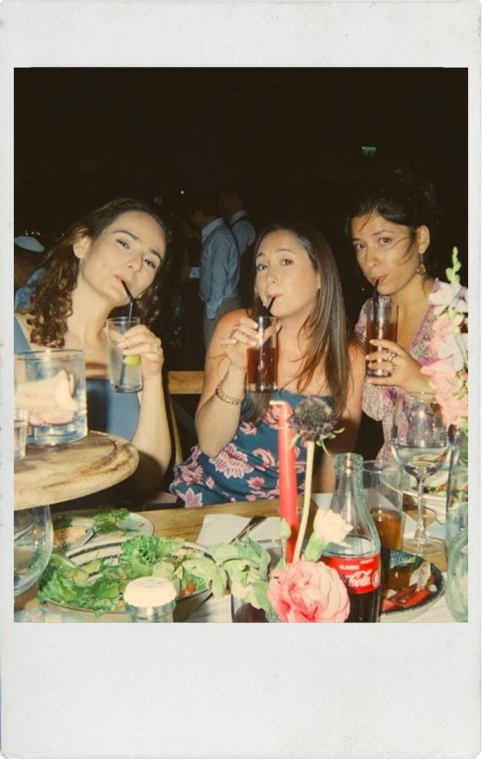 three friends drinking together at a candlelit dinner table
